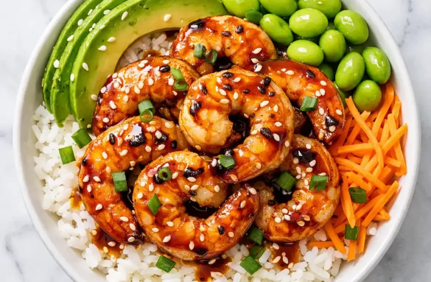 shrimp rice bowl with garlic butter shrimp avocado edamame carrots and sesame seeds overhead flat lay